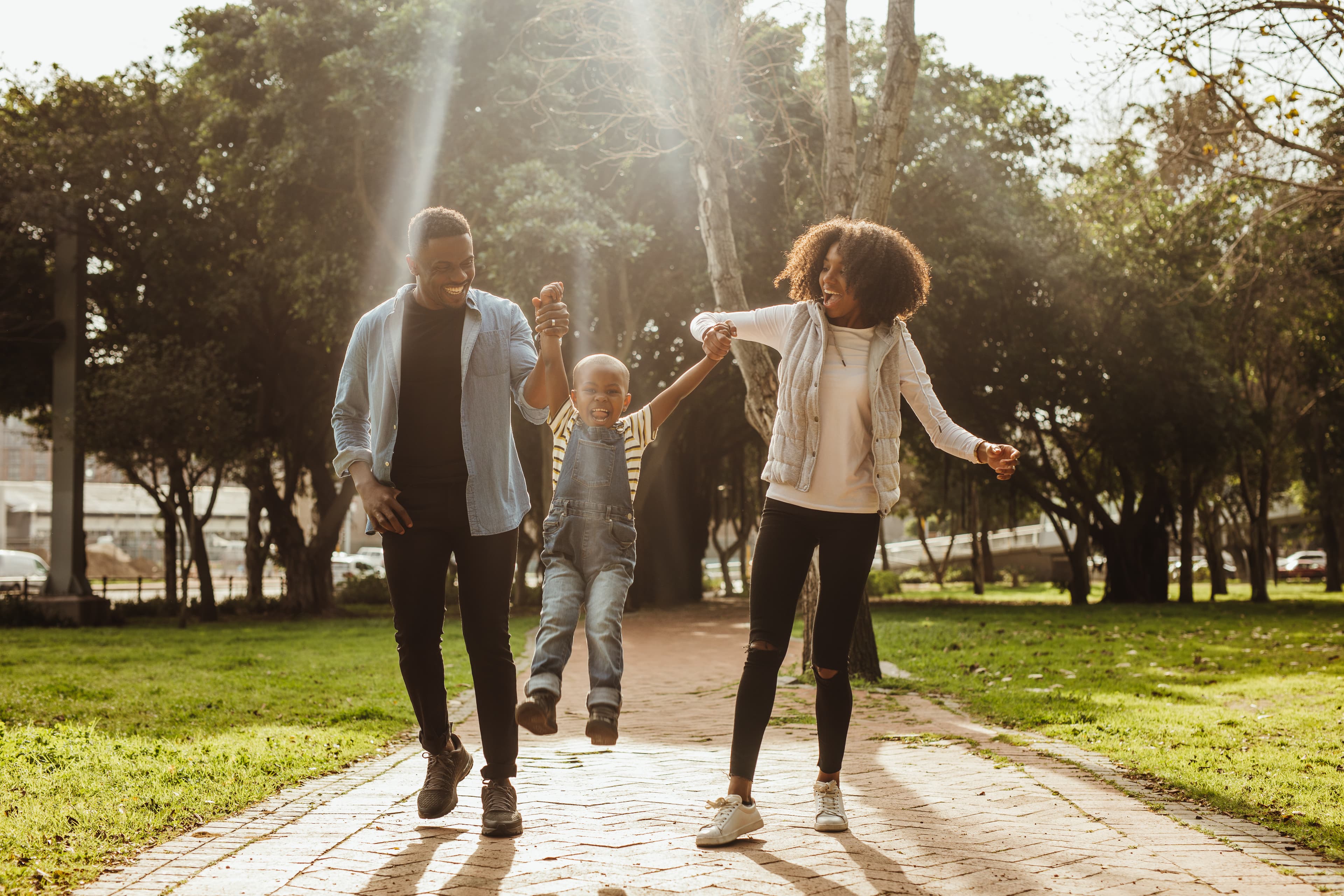Parents and son playing in a park, focused on mental health.