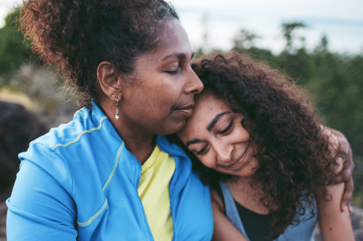 mom hugging teen daughter