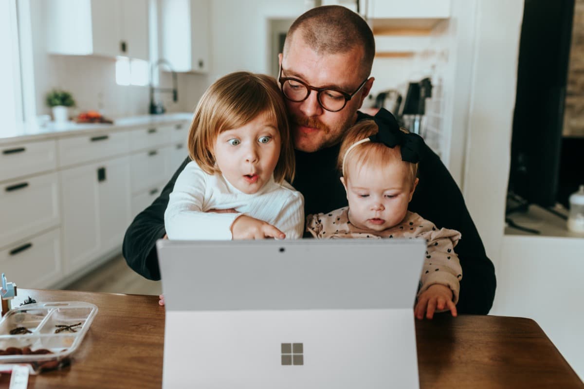 Caregiver and child at a computer together at home